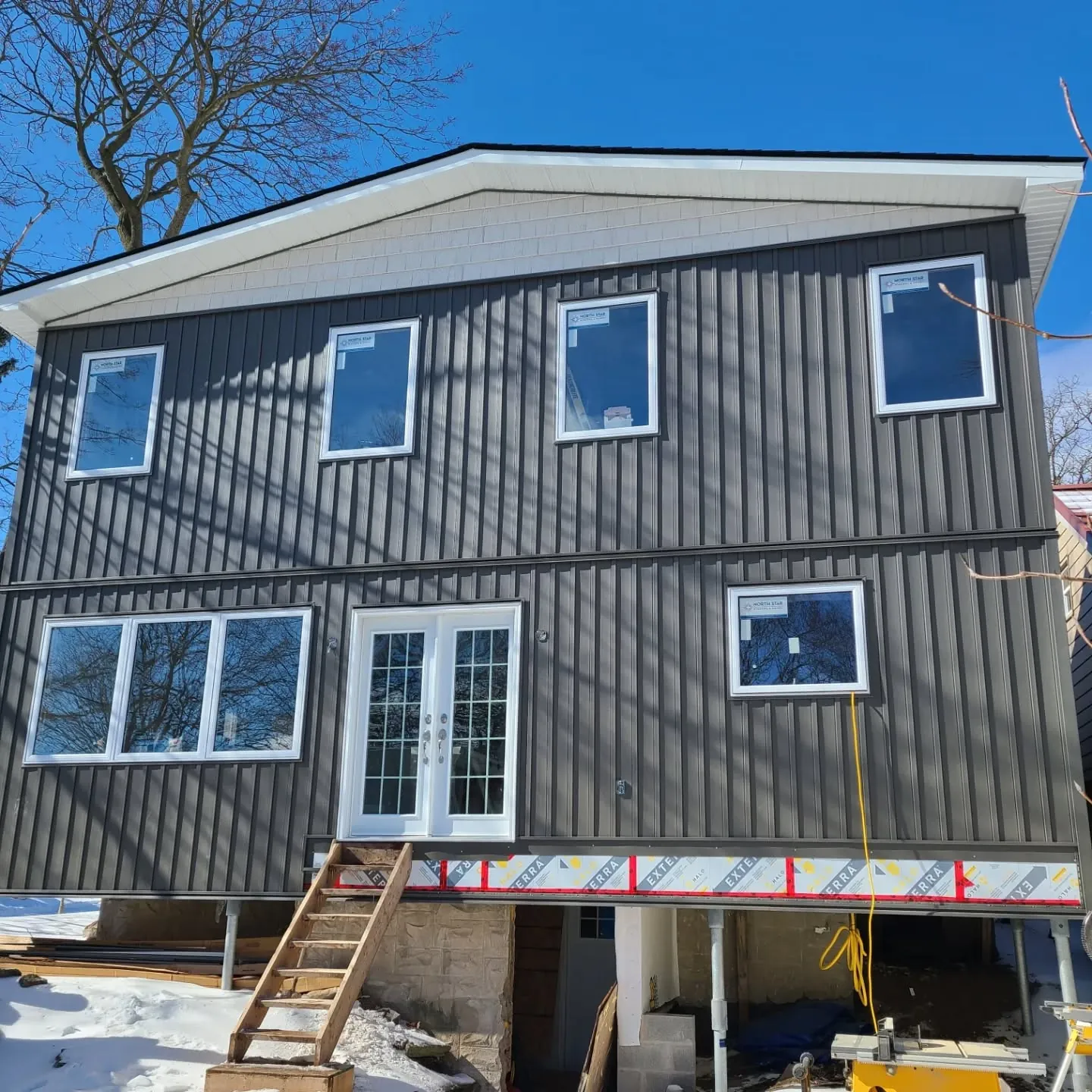 Two-storey addition with board-and-batten siding and new windows in Galt, Cambridge