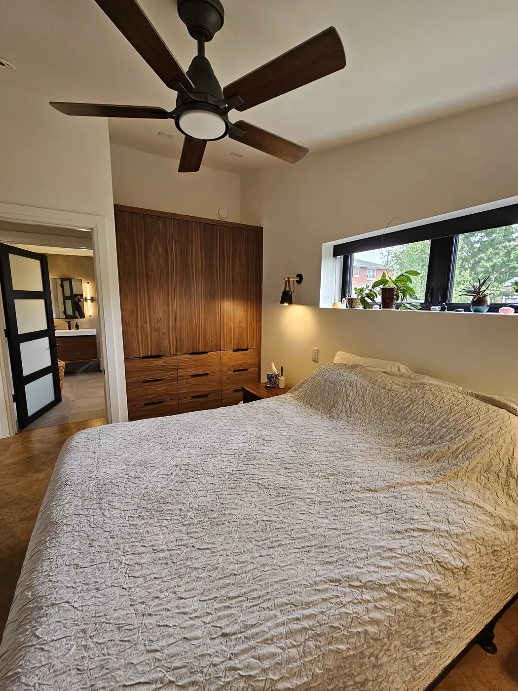 Bedroom with cork flooring, a vaulted ceiling, a clerestory window, and a walnut wardrobe
