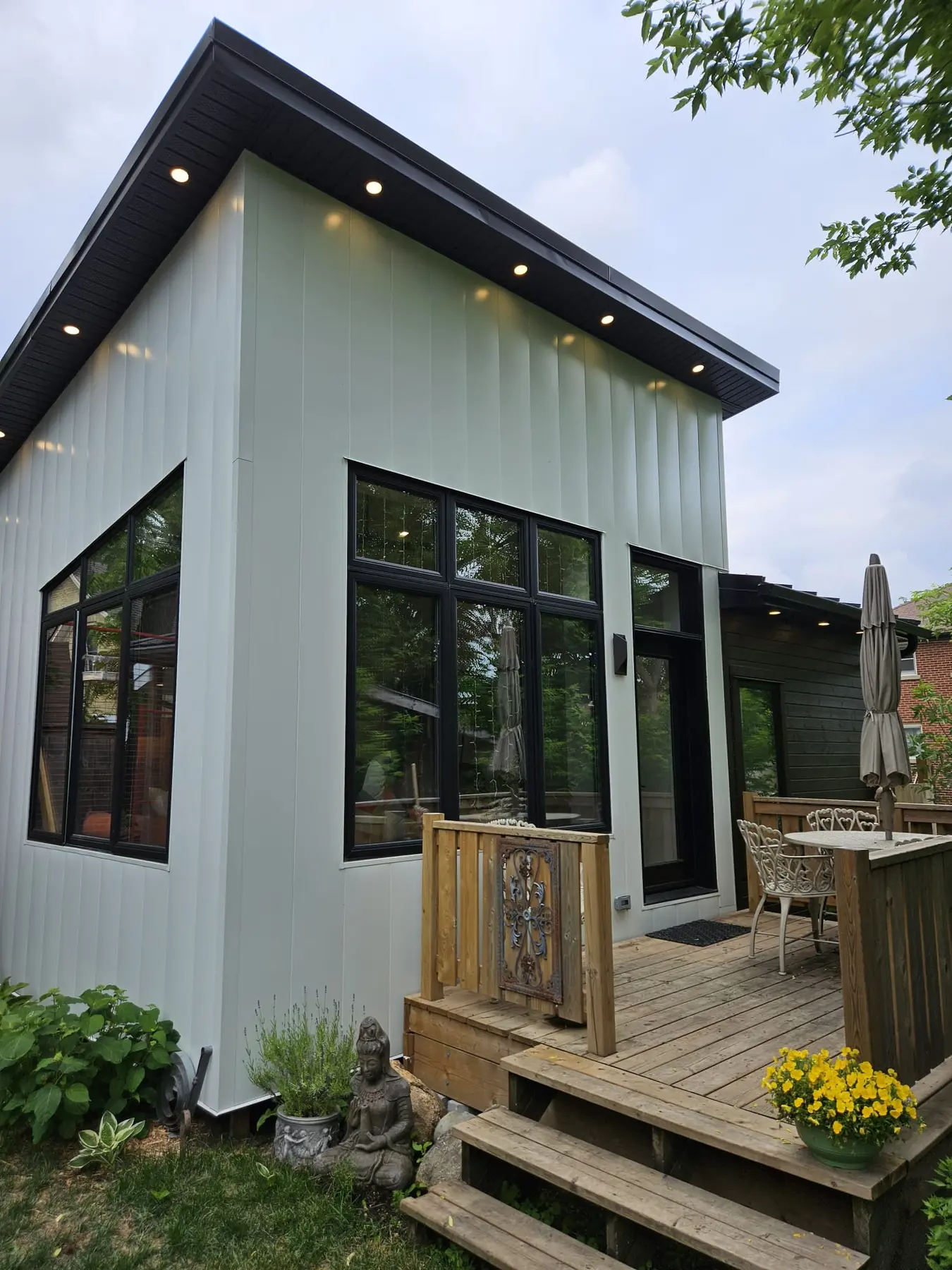 All-electric garden suite in Kitchener with vertical steel and wood siding, black-framed windows, and a low shed roofline