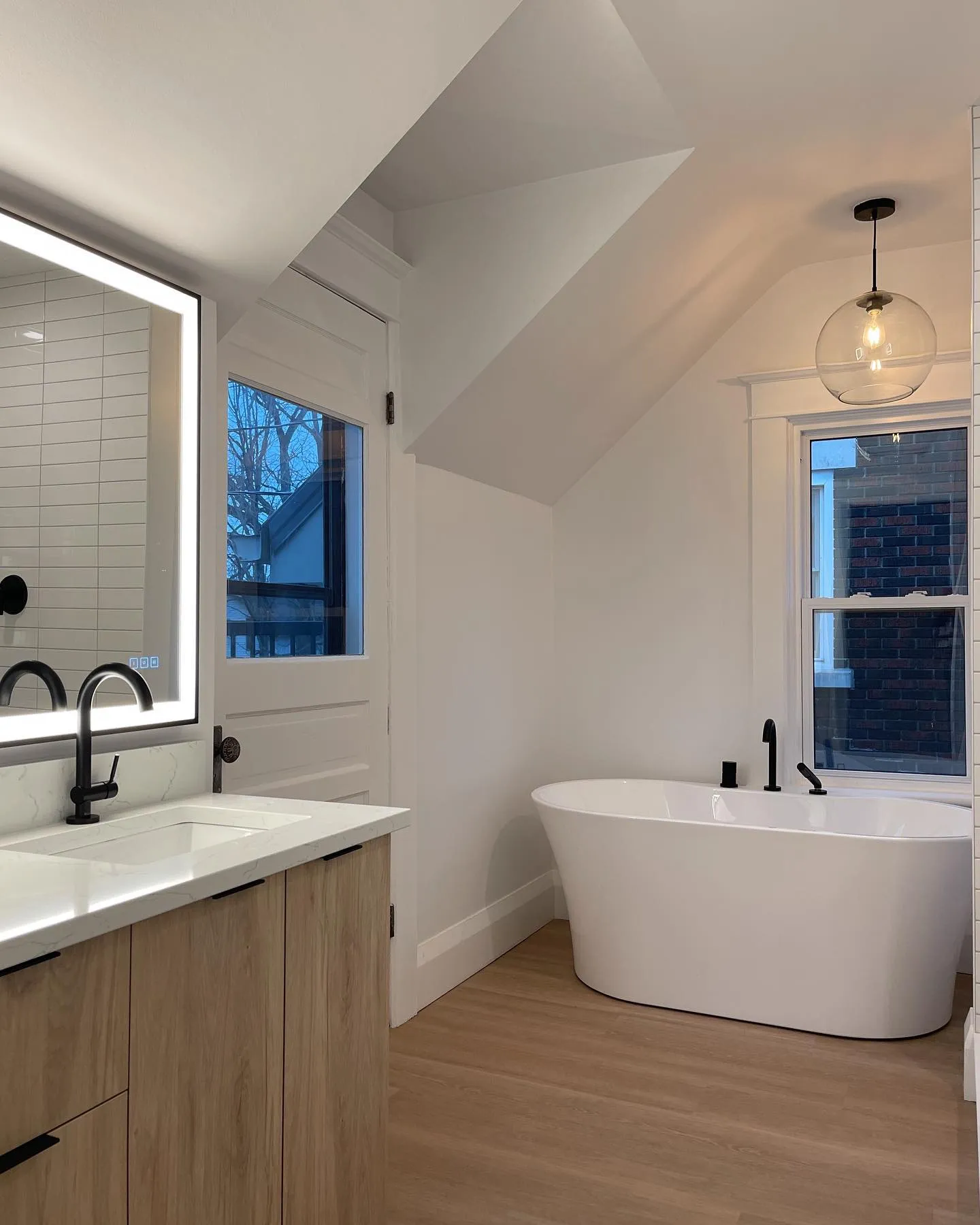 Ensuite with soaker tub and white oak vanity in Kitchener by Caliber Contracting