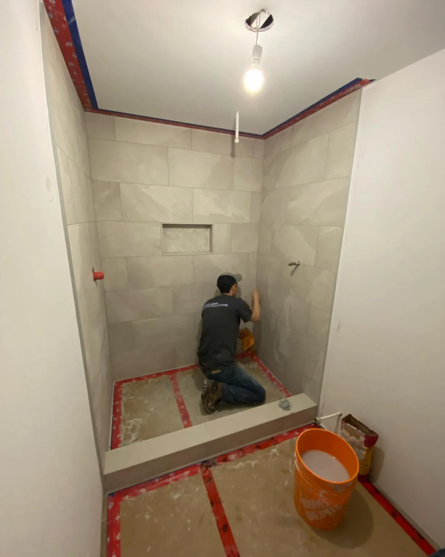 Precision shower tile installation by Caliber Contracting crew member