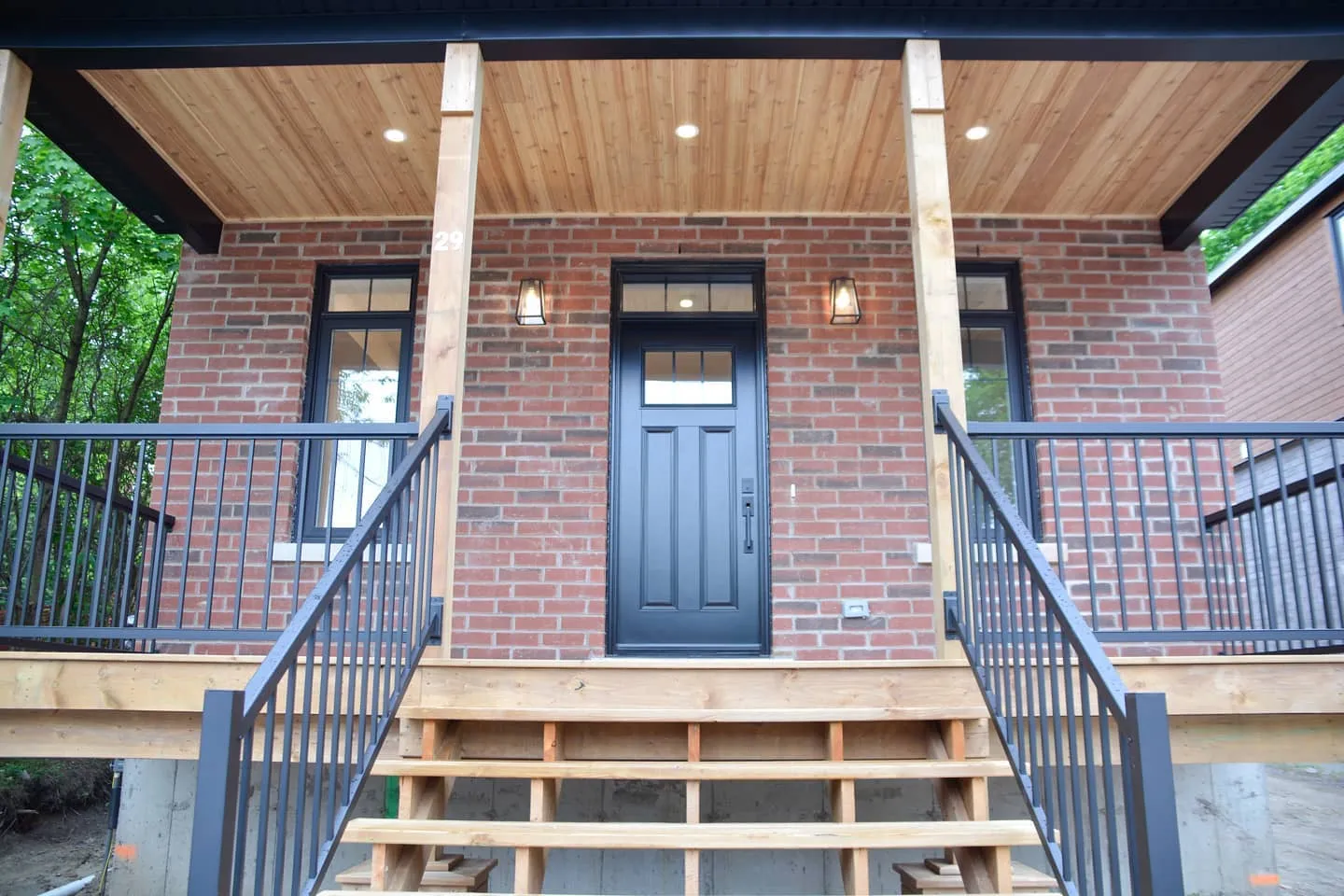 New custom home with brick and cedar porch in Kitchener by Caliber Contracting