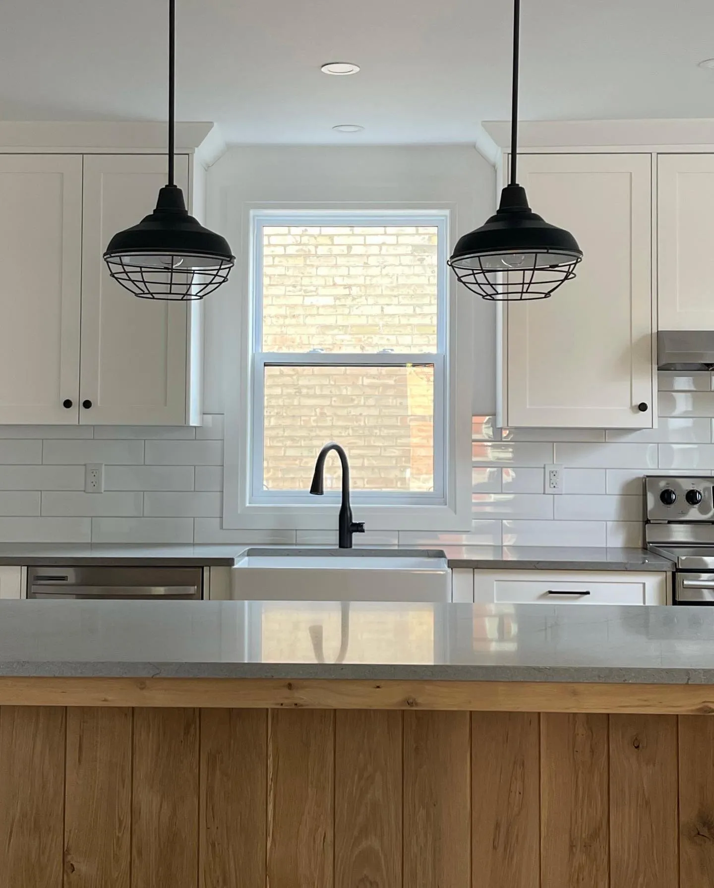 White oak island with waterfall countertop in Cambridge by Caliber Contracting