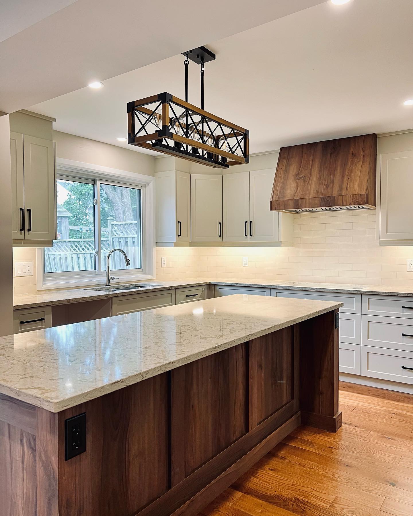 Custom kitchen with walnut range hood and island by Caliber Contracting in Waterloo Ontario